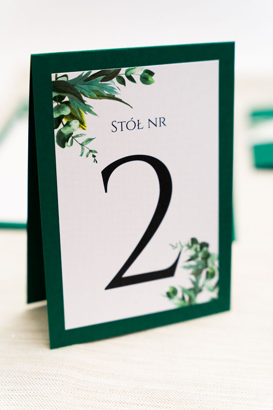 stylowe numery na stoły weselne z zielonymi listkami